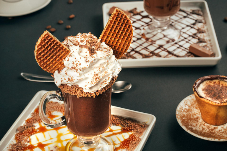 Chocolate quente gourmet servido em taça com chantilly, raspas de chocolate e waffles